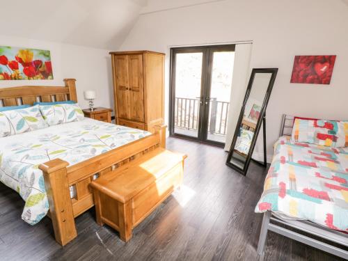 Doirí BeagaにあるDerrybeg Apartmentのベッドルーム1室(木製ベッド1台、ベッドスカート付)