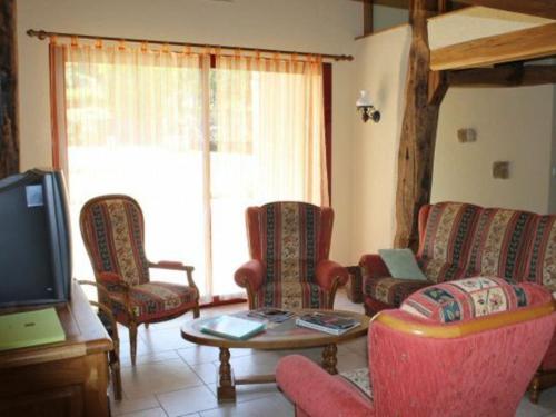 a living room with chairs and a table and a tv at Gîte de charme avec cheminée, terrasse et garage à Brixey-aux-Chanoines - FR-1-585-10 in Brixey-aux-Chanoines