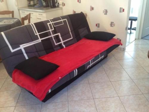 Bett in einem Zimmer mit einer roten Decke in der Unterkunft Gîte Étain, 2 pièces, 2 personnes - FR-1-585-3 in Étain