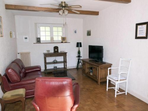 a living room with a couch and a television at Gîte pour 12 face au château de Thillombois avec jardin, cheminée et équipements PMR - FR-1-585-38 in Thillombois