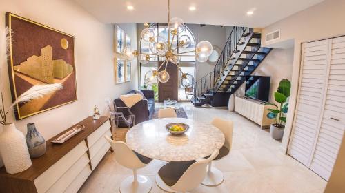 a dining room with a table and chairs and a staircase at Villas at St James Place UNIT F, Luxury, Pet Friendly in Miami