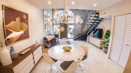 a dining room with a table and chairs and a staircase at Villas at St James Place UNIT F, Luxury, Pet Friendly in Miami