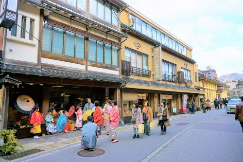 a group of people walking down a city street at Morizuya in Toyooka