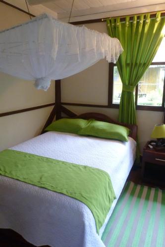 a bedroom with a bed with green sheets and a canopy at Yarina Eco Lodge in Derna