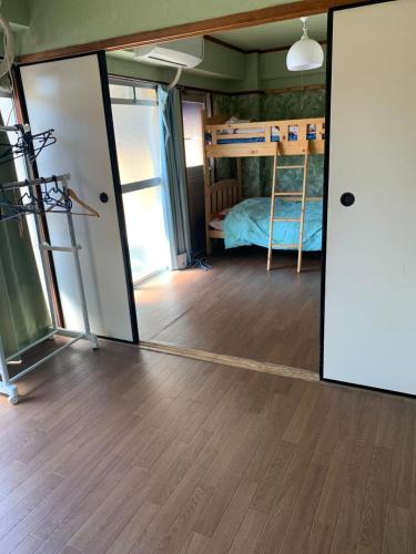 a room with a bunk bed and a mirror at 山下ビル５０２ in Sutara
