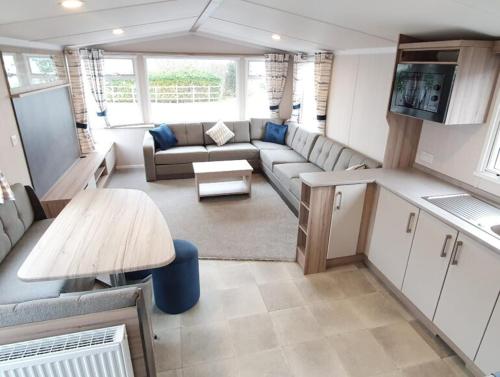 a living room with a couch and a table at Caravan on Fantastic site in Dunbar