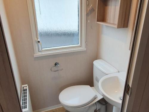 a small bathroom with a toilet and a sink at Caravan on Fantastic site in Dunbar