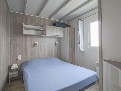 a bedroom with a blue bed in a room at Comfort in Grandcamp-Maisy in Grandcamp-Maisy