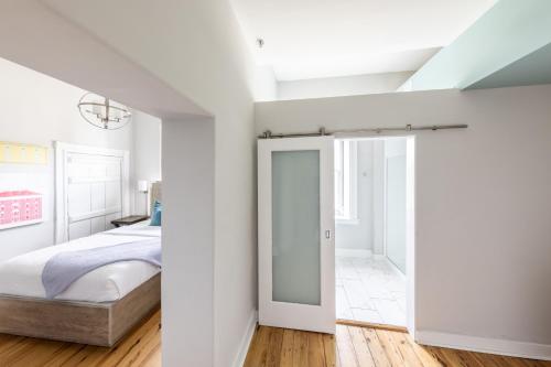 a white bedroom with a bed and a mirror at The Blackburn Inn and Conference Center in Staunton