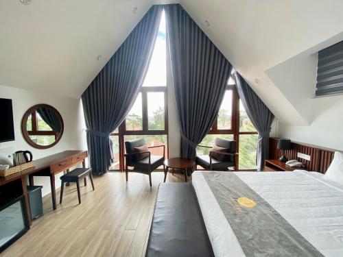 大叻的住宿－Duy Long Hotel，卧室配有一张床、一张书桌和窗户。