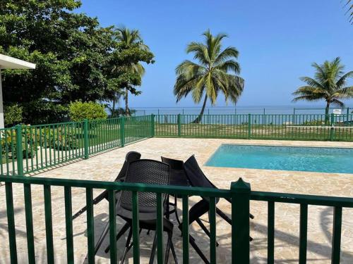 a chair next to a fence next to a swimming pool at MY DREAM BEACH HOUSE in Aguada