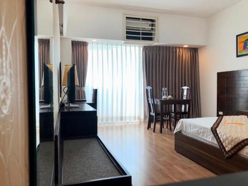 a bedroom with a bed and a desk and a table at Khách sạn Công Đoàn Quảng Bá in Hanoi