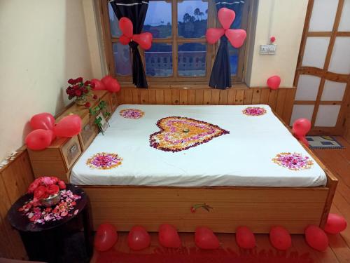 a bed in a room with a cake on it at Ritu Raj Home Stay & Cafe in Malther