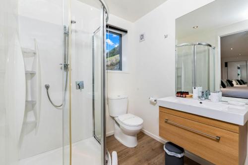 uma casa de banho com um WC e uma cabina de duche em vidro. em Quaint Sanctuary on Quartz em Queenstown