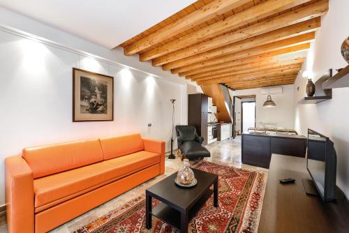 a living room with an orange couch and a table at Faber Apartments-Residence Style in Arona