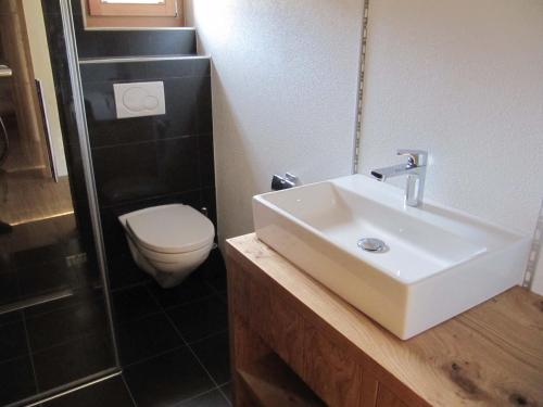 uma casa de banho com um lavatório e um WC em Swissalpschalet Chalet Timber Inn 4-5 em Blatten bei Naters