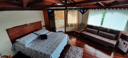 - une chambre avec un lit et un canapé dans l'établissement Flor da Vida _ Honeymoon suite - Vale do Capao, à Palmeiras
