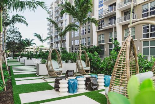 邁阿密的住宿－Tucker at Palmer Dadeland Miami，度假村的户外休息区配有椅子和棕榈树。