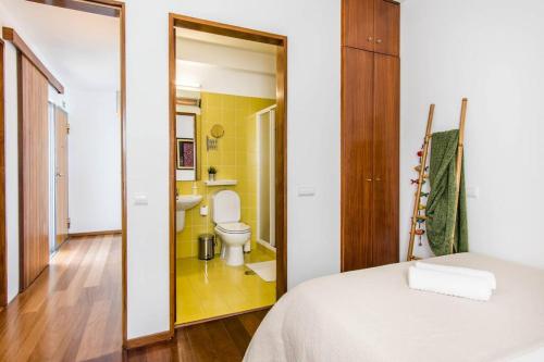 a bedroom with a bed and a bathroom with a toilet at Beachside Villa 5 Bdr 6 Baths Sleeps 9plus ppl in Aljezur