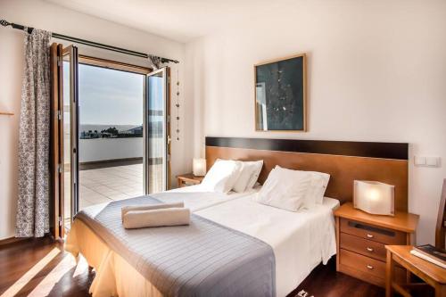 sypialnia z dużym łóżkiem i balkonem w obiekcie Beachside Villa 5 Bdr 6 Baths Sleeps 9plus ppl w Aljezur