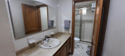 a bathroom with a sink and a toilet and a mirror at El Peñon del Rodadero - Apto 1303A in Santa Marta