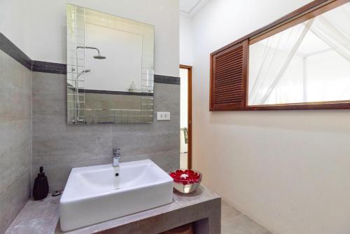 baño con lavabo blanco y ventana en Moon Cottage en Choeng Mon Beach