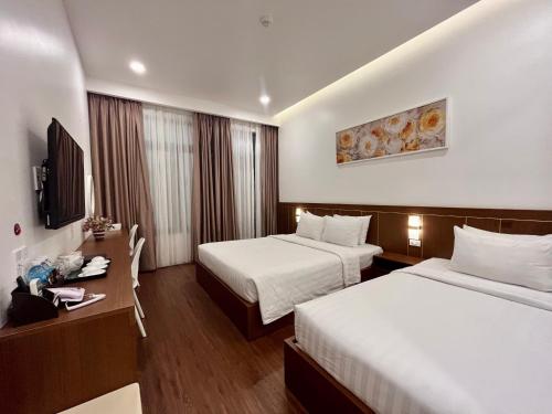 una camera d'albergo con due letti e una televisione di Marina Hotel Phú Yên a Tuy Hoa