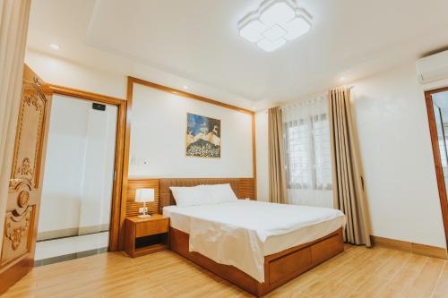 ein Schlafzimmer mit einem großen Bett und einem Fenster in der Unterkunft Bảo Châu Hạ Long Hotel in Hạ Long