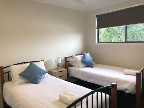 a bedroom with two beds and a window at 26 Rumbalara Avenue Rainbow Beach Aircon Walk To Beach in Rainbow Beach