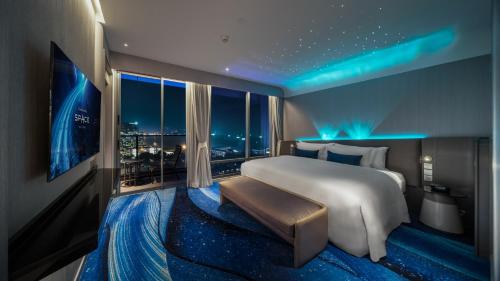 a bedroom with a large bed and a large window at Grande Centre Point Space Pattaya in Pattaya North