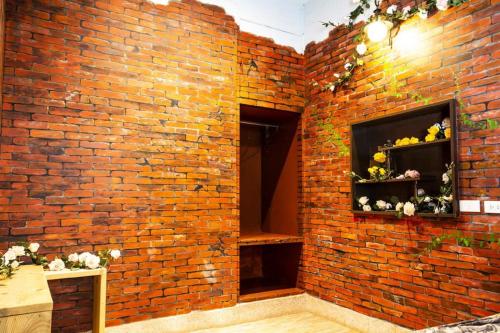 a brick wall with two shelves with flowers on it at Anping OAOA Homestay in Anping