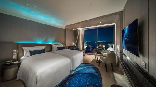 a hotel room with a large bed and a window at Grande Centre Point Space Pattaya in Pattaya North