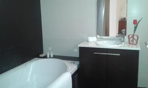 W łazience znajduje się wanna i umywalka. w obiekcie Lovely Apartment @ Aveiro's Downtown w mieście Aveiro