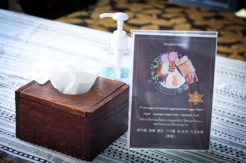 a wooden box sitting on a table with a bottle of soap at Vlodge House in Chiang Mai