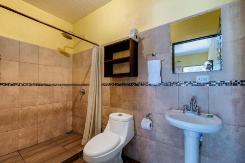 a bathroom with a toilet and a sink at Tropical Beach in Uvita