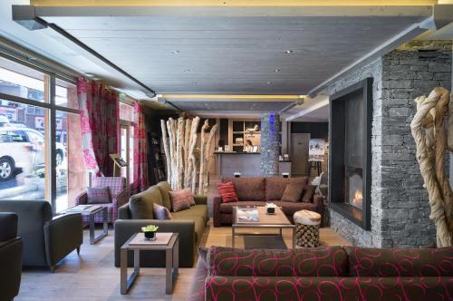 - un salon avec des canapés et un mur en briques dans l'établissement CGH Résidence Boutique Le Lodge Hemera, à La Rosière