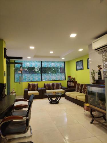 sala de estar con sofá, mesa y sillas en New Hotel Panda, en Katmandú