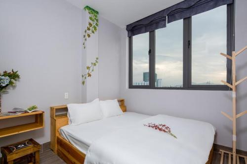 a bedroom with a bed and a large window at TUTI HOSTEL in Da Nang