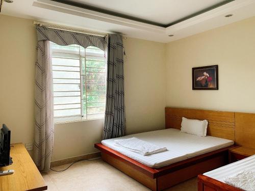 a bedroom with a bed and a window at RosePark Tuan Chau in Ha Long