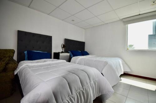 1 dormitorio con 2 camas con sábanas blancas y ventana en Room in Guest room - Habitacion Tipo Hotel En Obispado, en Monterrey