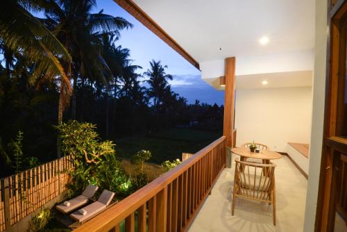 a balcony with a table and a view of the ocean at Purana Boutique Resort in Ubud