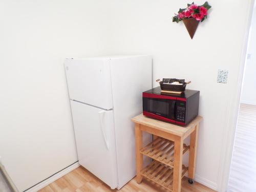 un forno a microonde seduto su un tavolo accanto a un frigorifero di Shoreline Cottages a Fort Bragg