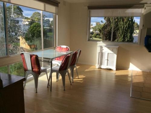 a dining room with a glass table and chairs at Lakes Entrance Views in Lakes Entrance