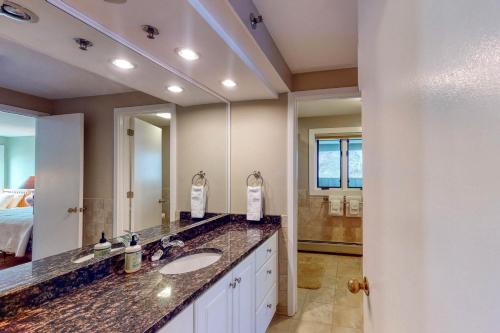 Un baño con lavabo y un espejo grande. en Forest Shadow, en Lincoln