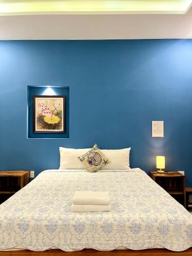 a blue bedroom with a bed with a blue wall at Catsen Bungalows & Pool Phan Thiet in Phan Thiet