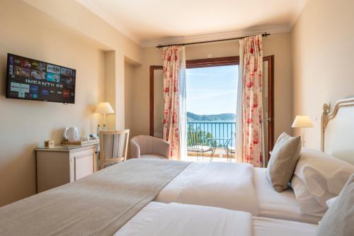 a bedroom with a large bed with a view of the ocean at Hotel Cala Fornells in Paguera