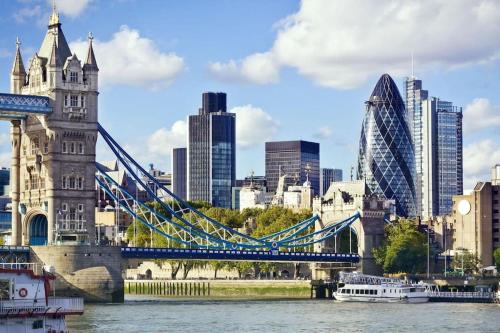 a suspension bridge over a river with a city at GORGEOUS FlatB Central London Liverpool St Station in London