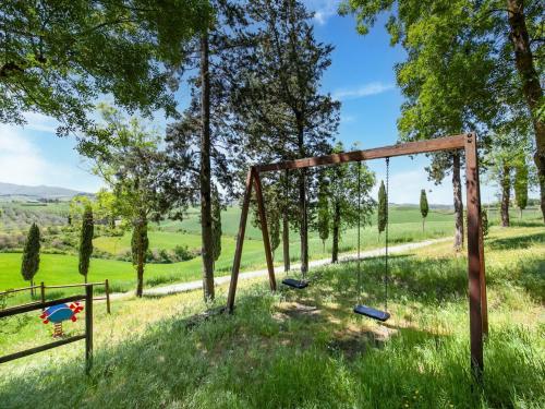 a swing set in a field with trees at Peccioli Villa Retreat w Pool in Peccioli