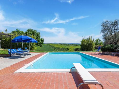 a swimming pool with two chairs and an umbrella at Peccioli Villa Retreat w Pool in Peccioli