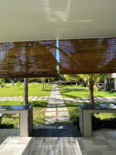 two benches in front of a park with trees at Catsen Bungalows & Pool Phan Thiet in Phan Thiet